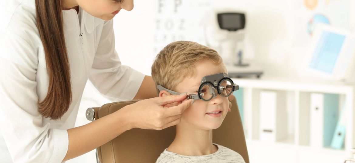 Ophthalmologist examining vision of little child in clinic