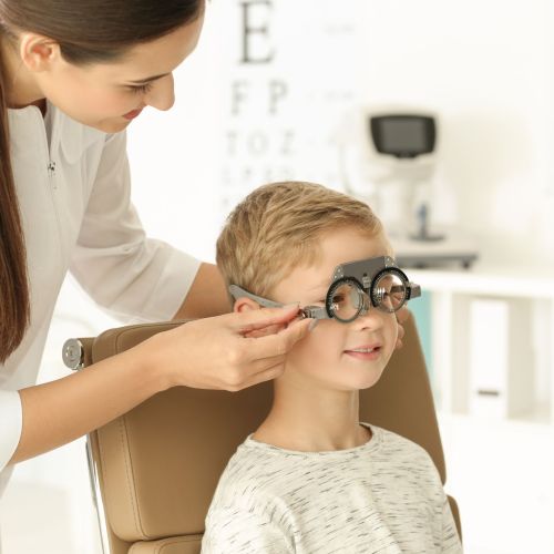Ophthalmologist examining vision of little child in clinic